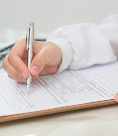Hand of doctor writing on prescription