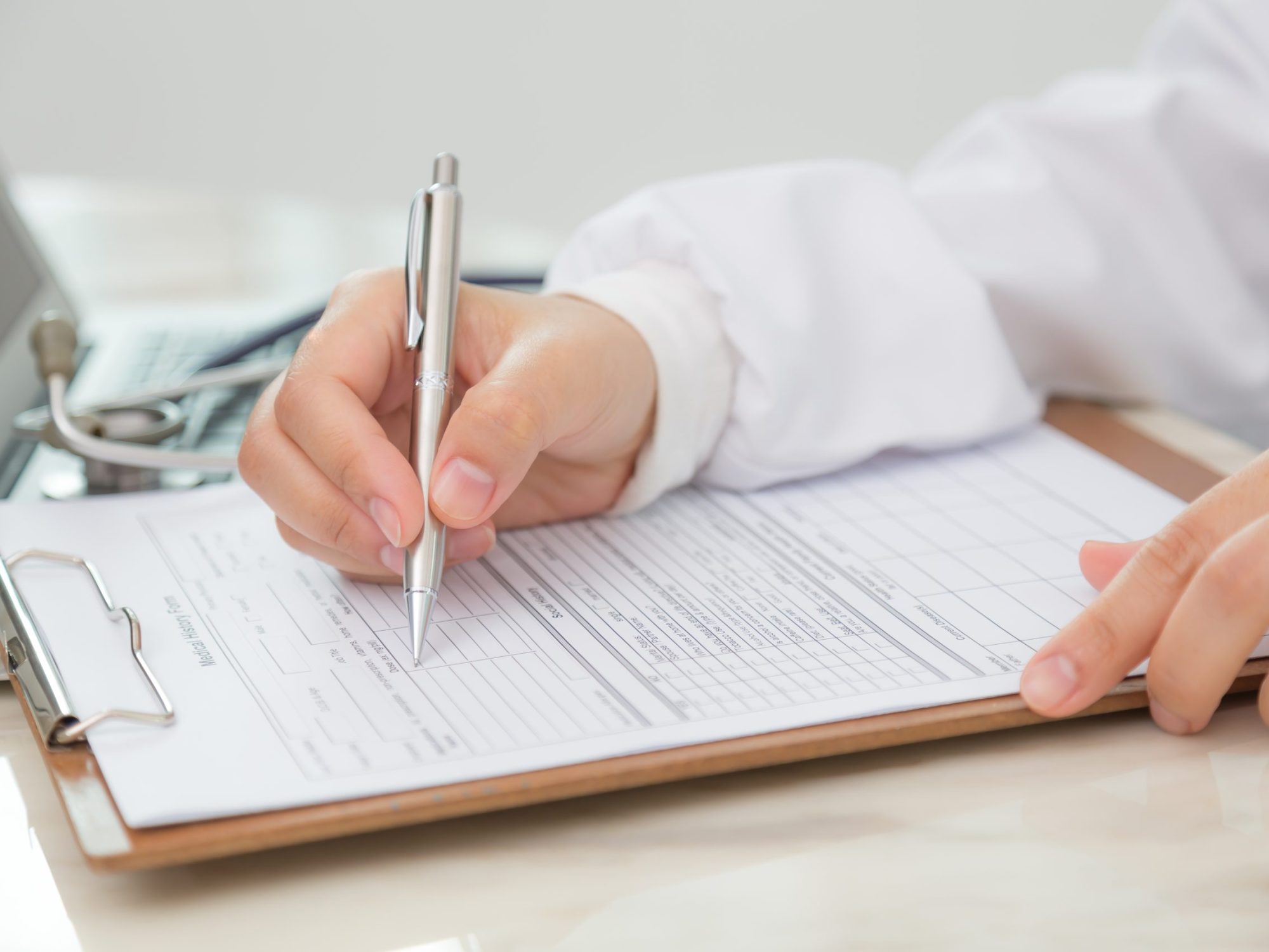 Hand of doctor writing on prescription